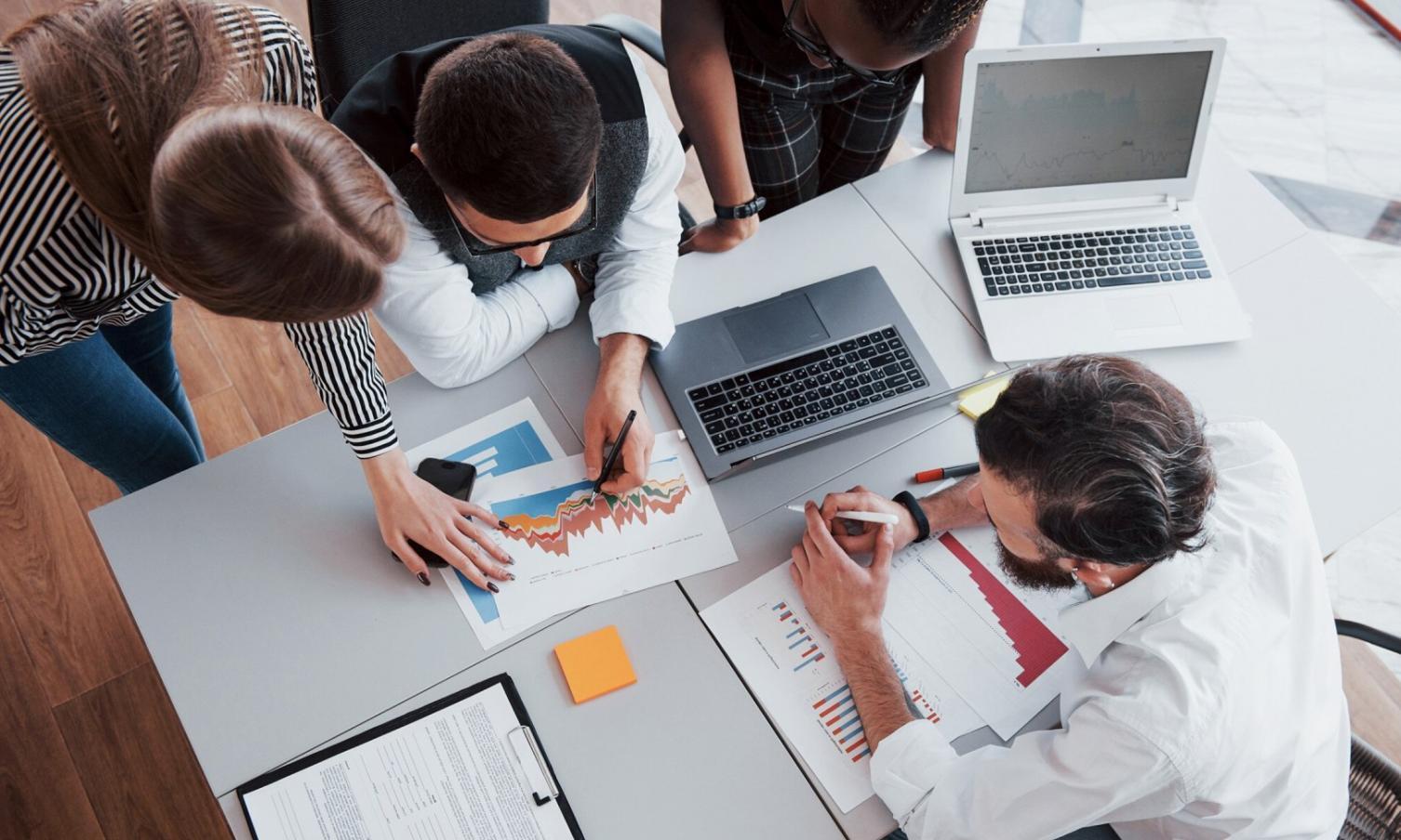 Person reviewing financial documents with calculator and charts, showing hands-on learning approach